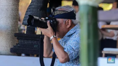 **Ringkasan:**

Menteri Basuki Hadimuljono tampil sebagai fotografer di World Water Forum ke-9 di Senegal. Ia mengenakan udeng, penutup kepala khas Bali, untuk menunjukkan budaya Indonesia dalam acara tersebut. Tindakan Menteri Basuki menuai pujian sebagai bentuk kreativitas dan kecintaan terhadap budaya Indonesia.